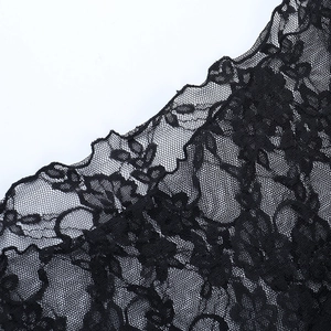 Close-up of black floral lace fabric on long sleeve top with intricate mesh details