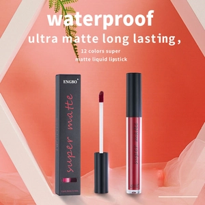 Detail view of deep red ultra matte liquid lipstick with applicator and black packaging