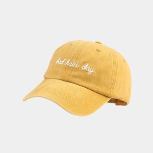 Macro detail of mustard yellow washed cotton baseball cap with bad hair day embroidery