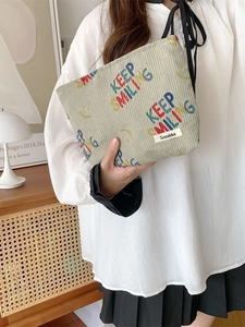 Corduroy keep smiling letter cosmetic bag in sage green held by model in home setting