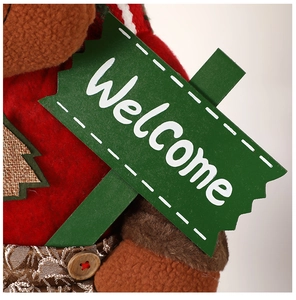 Close-up of plush Christmas decor with red fabric texture and green Welcome sign