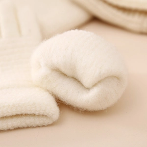 Detailed close-up of thick plush lining on warm cream knitted gloves for children