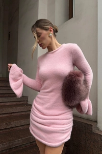 Détail de la texture en maille rose et poignets évasés sur une mini robe en tricot