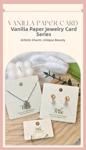 Detail showing jewelry display cards with gold logo, necklace and pearl earrings