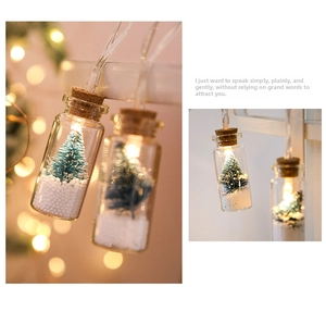 Detail of LED wish bottle lights featuring mini Christmas trees and artificial snow inside