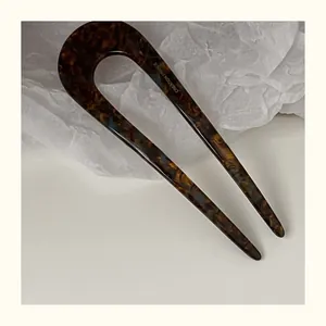 Detail of tortoise shell acetate U-shape hair pin with polished finish and engraving