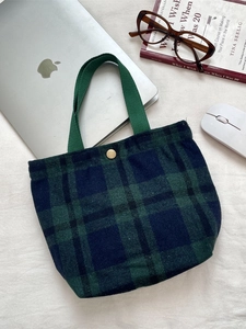 Borsa bento retrò in lana a quadri verde scuro con bottone a pressione dorato su scrivania