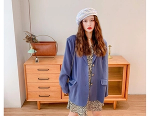 Fashionable model wearing a white sequin beret paired with a purple oversized blazer