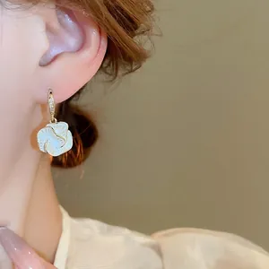 French camellia drop earrings with gold plating and zircons worn by a model