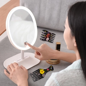 Close-up of the touch sensor base and LED lighting function on a white round makeup mirror