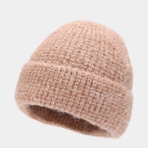 Close-up of thick light brown bouclé knit beanie showing fluffy texture and ribbed cuff