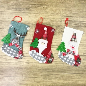 Three linen Christmas stockings with reindeer, Santa, and snowman felt appliques on wood