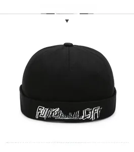 Detail of black cotton docker cap featuring white graffiti letter embroidery on front