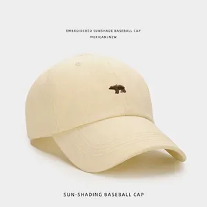 Gros plan détaillé sur une casquette en coton crème avec broderie d'ours polaire