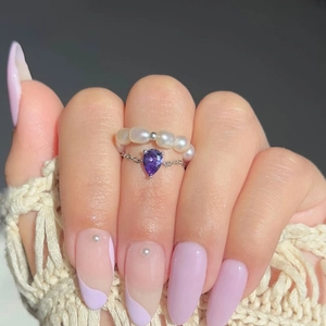 Détail d'un ensemble de bagues plaqué or 18 carats avec pierre violette et perles d'eau douce