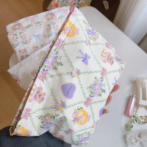 Detail of floral printed makeup bag featuring cute bear pattern and metal zipper closure