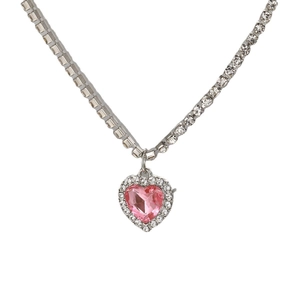 Macro shot of pink heart pendant with silver tennis chain featuring pave zircon setting