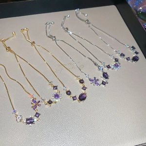 Macro shot of adjustable bracelets with purple zircons and butterfly floral charms