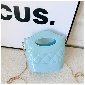 Dettaglio della mini borsa a secchiello in PVC azzurro con trama trapuntata e catena d'oro