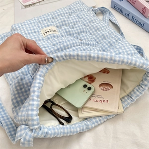 Detail view of quilted heart pattern bag showing interior storage for phone and glasses