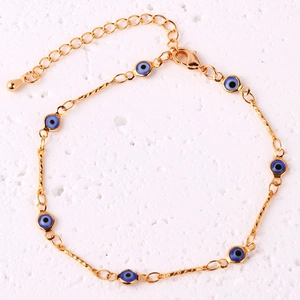 Detailed shot of a gold-plated evil eye link bracelet with blue charms and lobster clasp