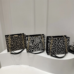 Minimalist animal print chain shoulder bags in leopard and zebra patterns on display