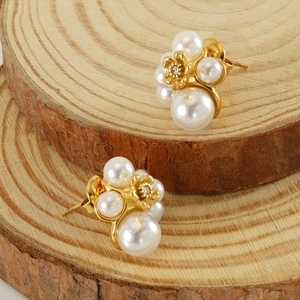 Detailed close-up of pearl cluster earrings with central golden flower and crystal stud