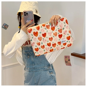 Padded laptop sleeve with colorful heart patterns being held by a girl in a mirror photo