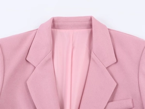 Detailed view of pink blazer lapel showing high-quality fabric texture and clean tailoring