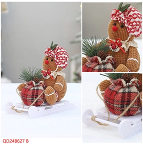 Detail of gingerbread man plush with red checkered hat holding gift bag on white sleigh