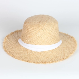 Close-up of fine raffia straw weaving texture with a wide white ribbon and frayed brim edge