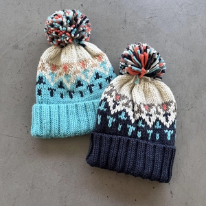 Winter knitted hats in light and dark blue with jacquard patterns and cute pom-poms