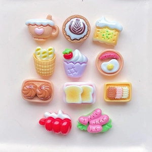Flat lay of miniature resin food charms including coffee, cakes and snacks for DIY crafts
