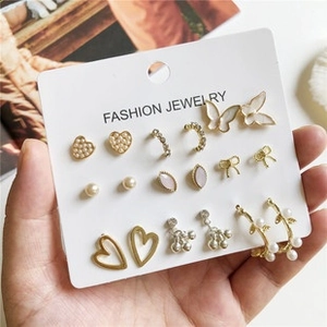 Detailed close-up of fashion gold earring set featuring heart and butterfly charms