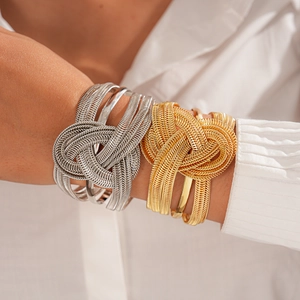 Detailed view of layered metallic knot cuff bracelet in gold and silver finish