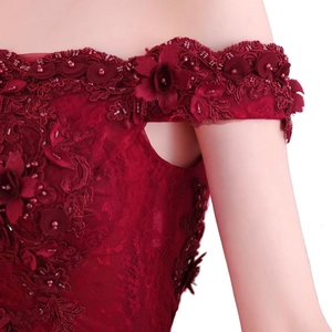 Détail de robe bordeaux à épaules dénudées avec dentelle 3D, perles et paillettes