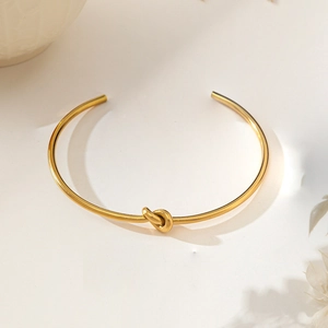 Elegant 18K gold plated titanium steel open knot bracelet with a minimalist design
