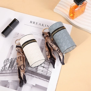 Mini PU leather round coin purse with woven texture and decorative ribbon keychain