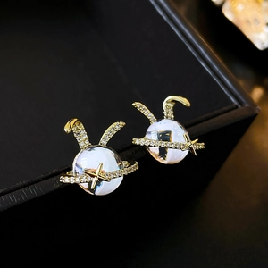 Macro view of gold plated rabbit planet stud earring with sparkling zircon inlays