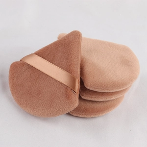 Close-up of four teardrop-shaped makeup puffs in beige and brown soft sponge material