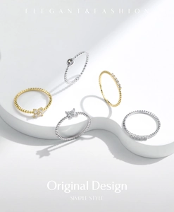 Macro di anelli in argento e oro con design a farfalla e quadrifoglio su base bianca