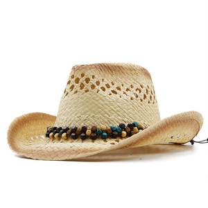 Détail d'un chapeau de cowboy en paille avec tissage ajouré et bande de perles bohème