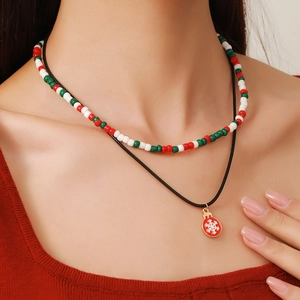 Detail of a double-layered Christmas necklace with colorful glass beads and a snowflake pendant