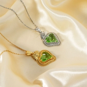 Detailed view of green heart-cut gemstone pendants on gold and silver necklaces