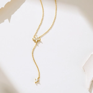 Detailed macro view of gold-plated Y-shaped necklace featuring sparkling zircon star charms