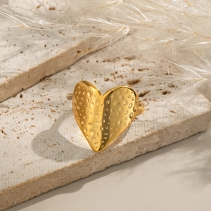 Bague en forme de cœur dorée avec surface texturée sur pierre naturelle
