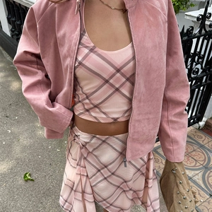 Details einer rosa Wildlederjacke über passendem Set aus kariertem Top und Rock