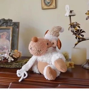Plush Christmas reindeer with knitted scarf and sequin hat on a cozy wooden shelf