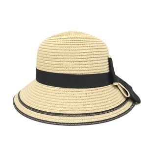 Detail of hand-woven straw hat with black ribbon bow and textured wide brim for summer