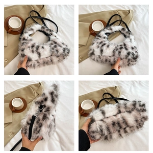 Detail view of plush black and white spotted crescent bag with smooth PU leather strap